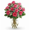Pink roses arranged in a clear glass vase with baby's breath