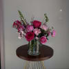 Pink and magenta flowers arranged in a clear glass vase