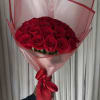 Bouquet of red roses wrapped in pink paper with a red ribbon