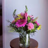 Mixed bouquet of pink and yellow flowers in a clear glass vase
