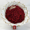 Bouquet of red roses wrapped in white and gold paper