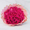 Bouquet of bright hot pink roses wrapped in layered pink and peach paper