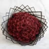 Bouquet of deep red roses wrapped in geometric black paper