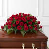 Red rose casket spray on a wooden coffin