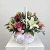 A charming wooden basket filled with a radiant mix of colorful lilies