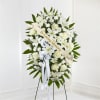 White funeral standing spray with roses and lilies on an easel