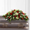 Red roses and white flowers arranged on a casket