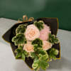 Bouquet of pale pink roses and a pink chrysanthemum with variegated green foliage