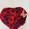 Heart-shaped box of red roses with a butterfly decoration
