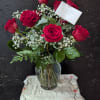 Deep, velvety red roses clustered with airy white baby's breath create a