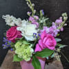 Cube vase includes roses, stock, alstroemeria, green hydrangea, statis, greens