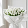 Bouquet of white tulips wrapped in white paper with a ribbon