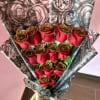 Bouquet of red roses wrapped in black-and-silver floral paper