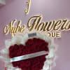 A large heart-shaped bouquet of deep red roses designed for Mother's Day