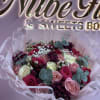 A lush hand-tied flower arrangement of tightly packed roses in hot pink