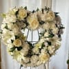Cream floral heart wreath on a black stand