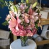 (ONE-SIDED) This arrangement features soft pink lilies, blush roses, delicate alstroemeria, and