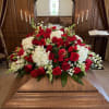 Red and white funeral spray with roses, carnations, hydrangeas and snapdragons, lush
