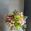 Mixed bouquet with pink and cream flowers in a white vase