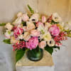 Pink and white flower arrangement in a green vase