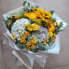 Bouquet of sunflowers, hydrangeas, and yellow roses wrapped in white paper