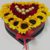 Heart-shaped box of red roses and yellow sunflowers with chocolates