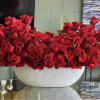 Large arrangement of red roses in a white bowl vase