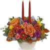 Fall floral centerpiece with two red taper candles in a white bowl