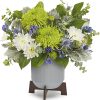 White and green floral arrangement in a gray vase