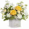Yellow roses and white flowers arranged in a square vase