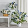 Soft blue delphinium spikes and pale hydrangea clusters meet classic white roses