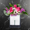 Pink roses and white daisies arranged in a rectangular vase