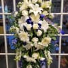 White funeral spray with lilies, roses, and chrysanthemums on a stand