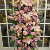 Tall pink floral standing spray with lilies, roses, and carnations