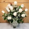 White roses arranged in a glass vase with baby's breath