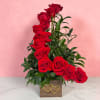 Red roses arranged in a wooden box with gold heart accents