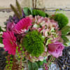 Pink gerberas and roses with hydrangea and green pom-pom blooms in a vase