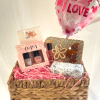 A cheerful woven gift basket arranged on a bed of pink shredded