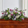 Low floral spray with pink roses, white blooms, and purple flowers
