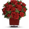 Red carnations arranged in a square glass vase