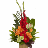 Tropical floral arrangement with red, orange, and green blooms in a wooden container