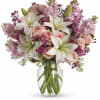 Pink roses and white lilies in a clear glass vase