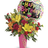 Birthday balloon above a colorful flower arrangement in a pink vase