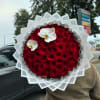 Large round bouquet of red roses with two white orchids