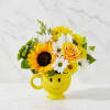 Yellow mug with a smiley face holding sunflowers, daisies, and a yellow rose