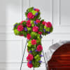 Cross-shaped floral tribute with pink roses and bright mixed blooms