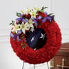 Red floral funeral wreath with white lilies and purple irises on a stand