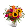Bouquet of sunflowers, roses, and carnations in a clear glass vase