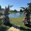 Two tall floral pillars flank a lakeside lawn