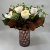White roses and green blooms in a textured glass vase